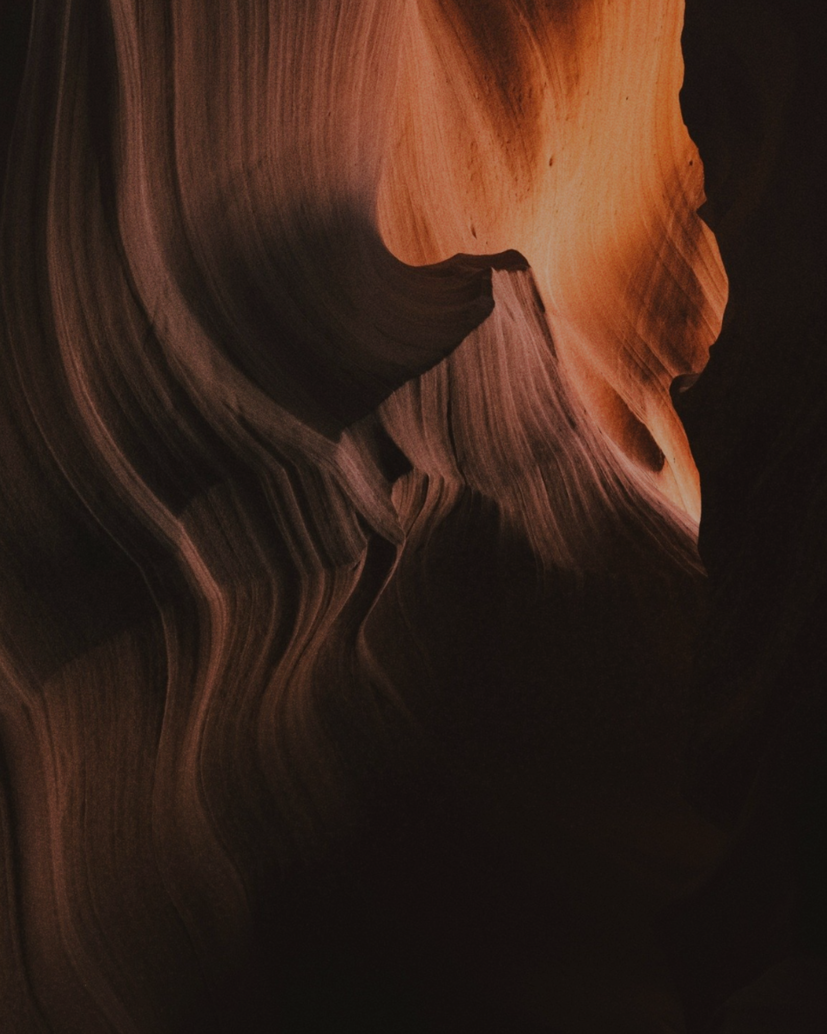 Close-up of sandstone formations with a dark background